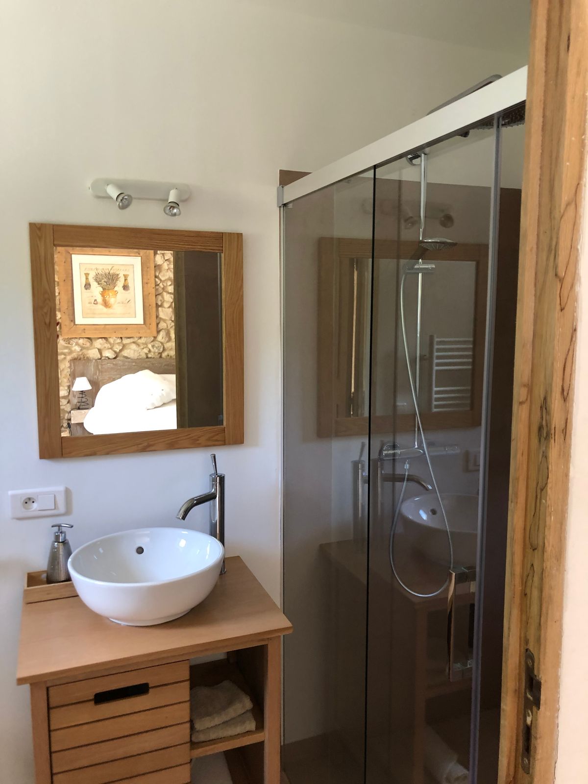 Room 4’s shower room: a basin on a wooden unit, a mirror and a glass shower.