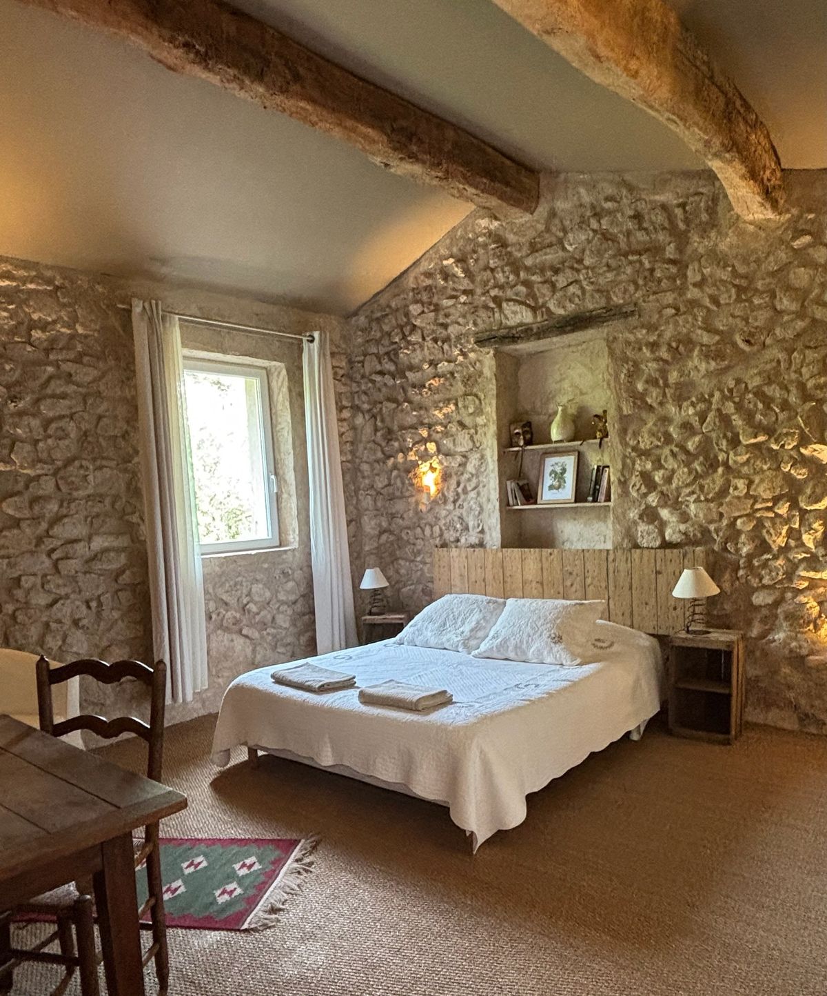 Room 5, upstairs: beams, stone walls, a lit niche and a double bed.