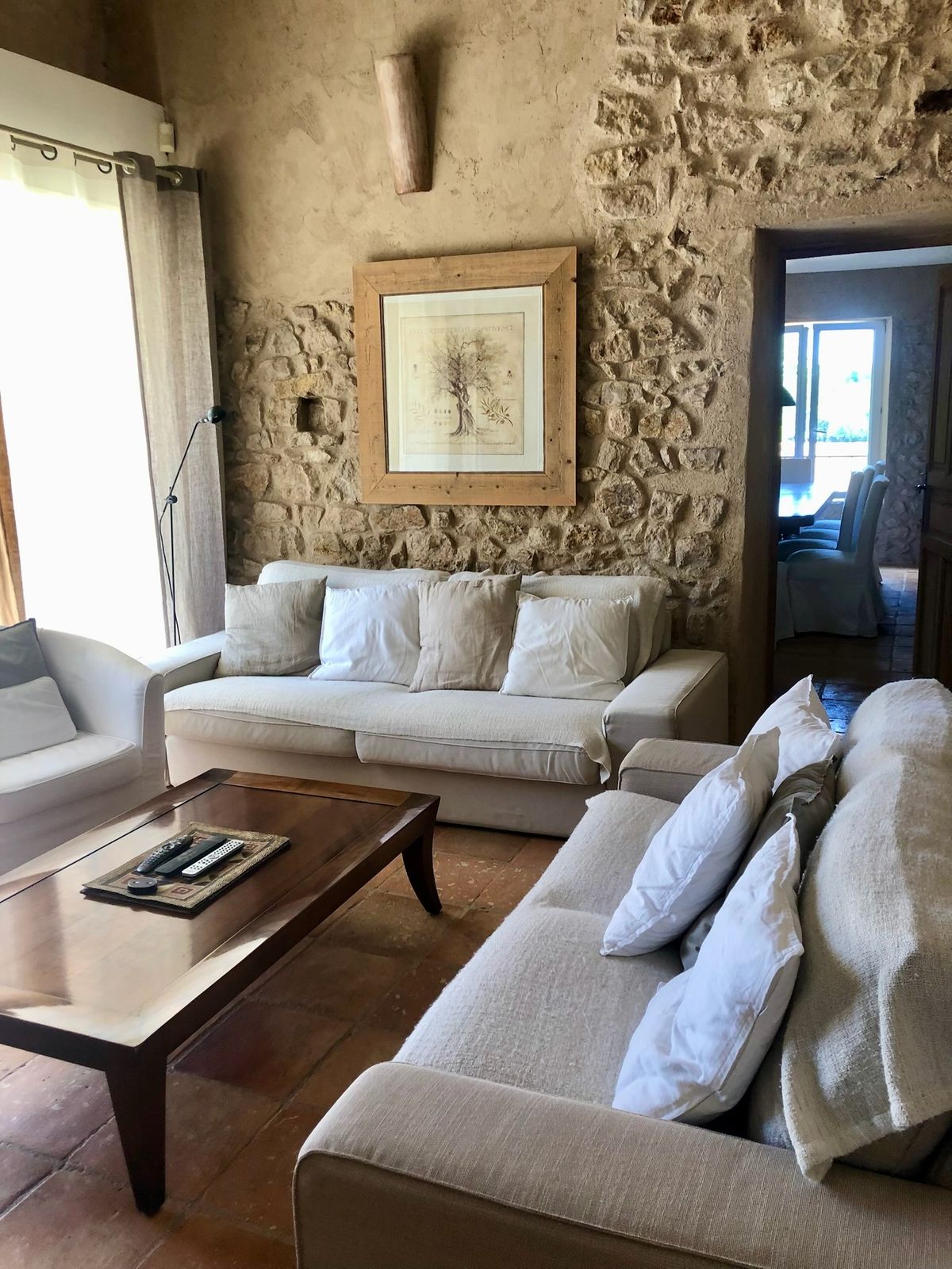 The sitting area: two pale sofas facing each other in front of a dressed stone wall.