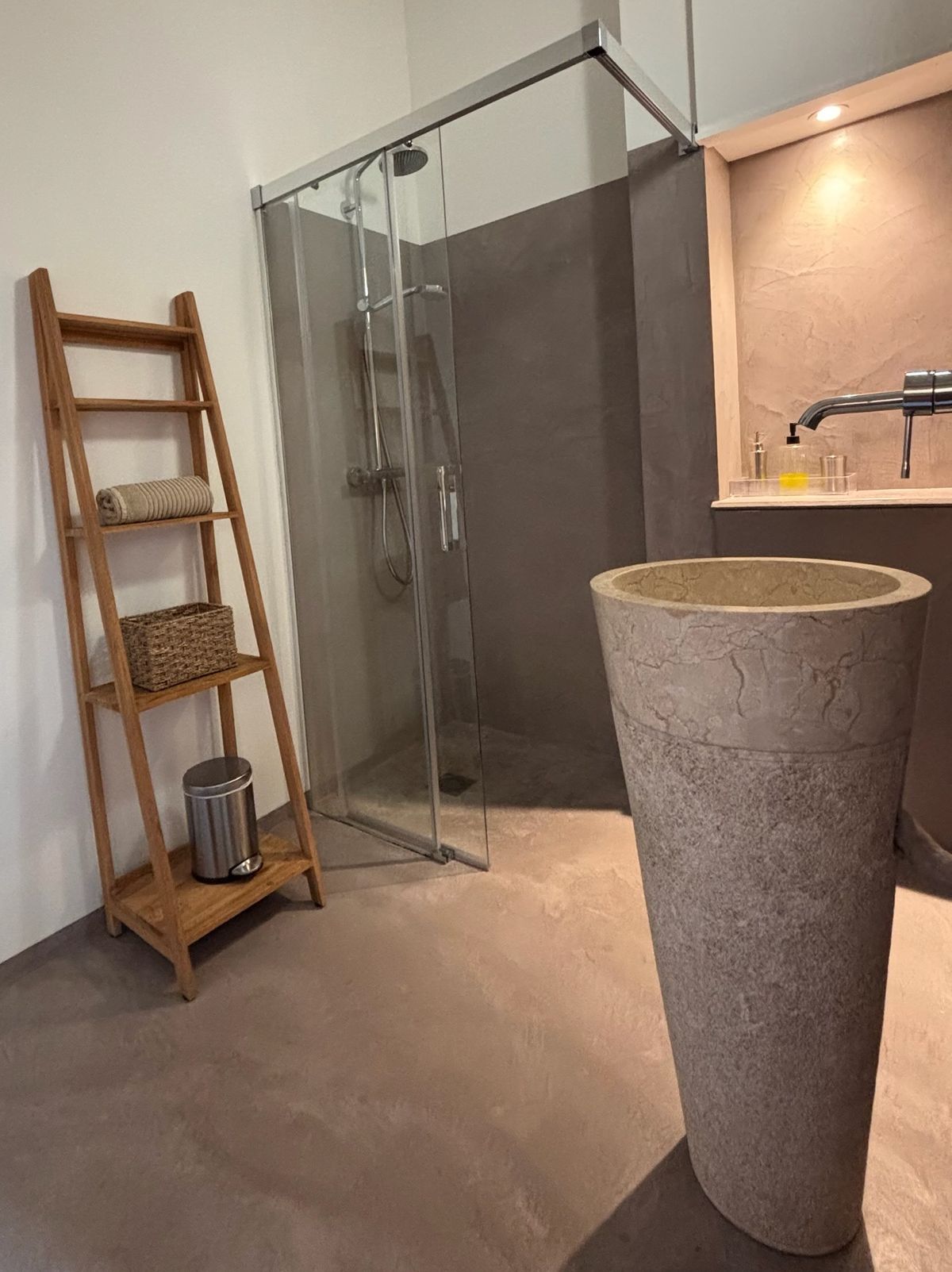 The shower room shared by rooms 5 and 6: glass shower, stone pedestal basin and towel ladder.