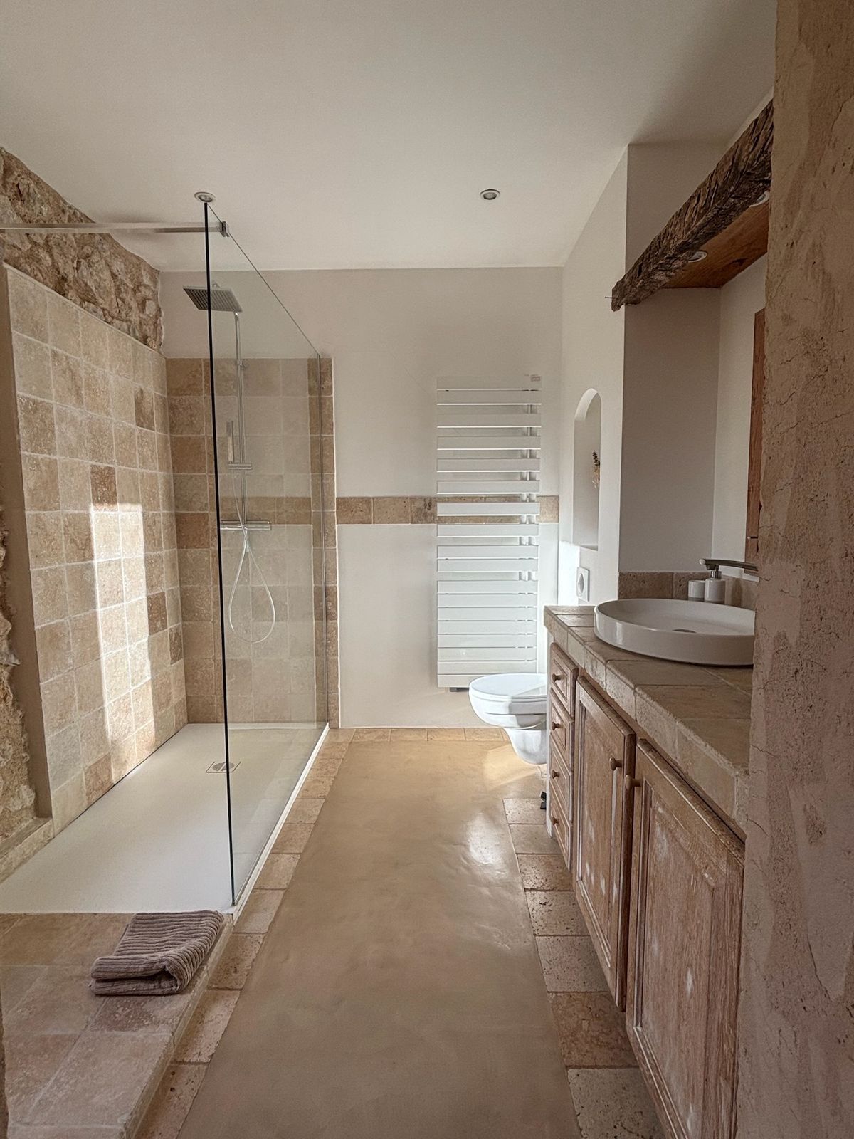 Room 1’s shower room: glass walk-in shower, wooden vanity unit and heated towel rail.