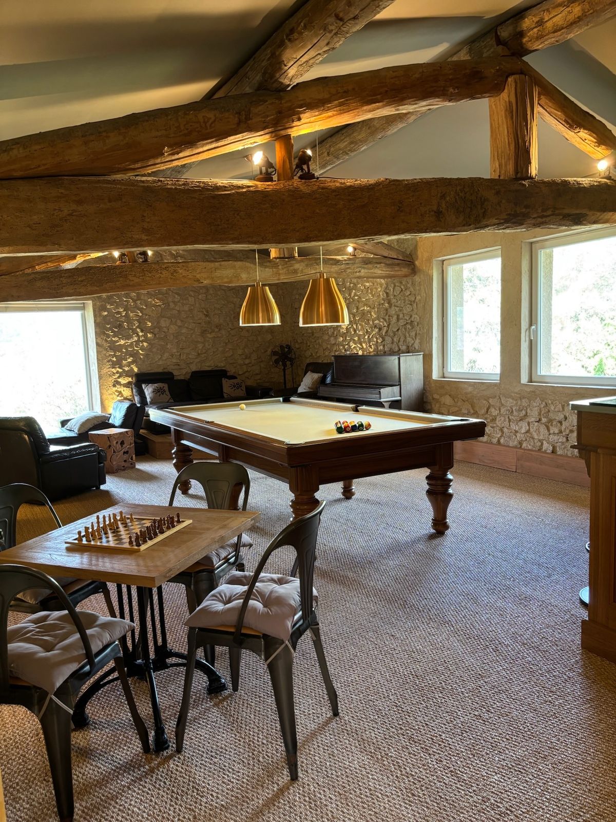 The games room under the beams upstairs: billiard table, chess table and sofas.