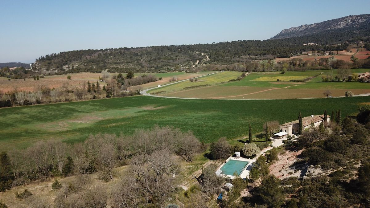 The fields and hills around the house seen from above; the house’s pool bottom right, mountains on the horizon.