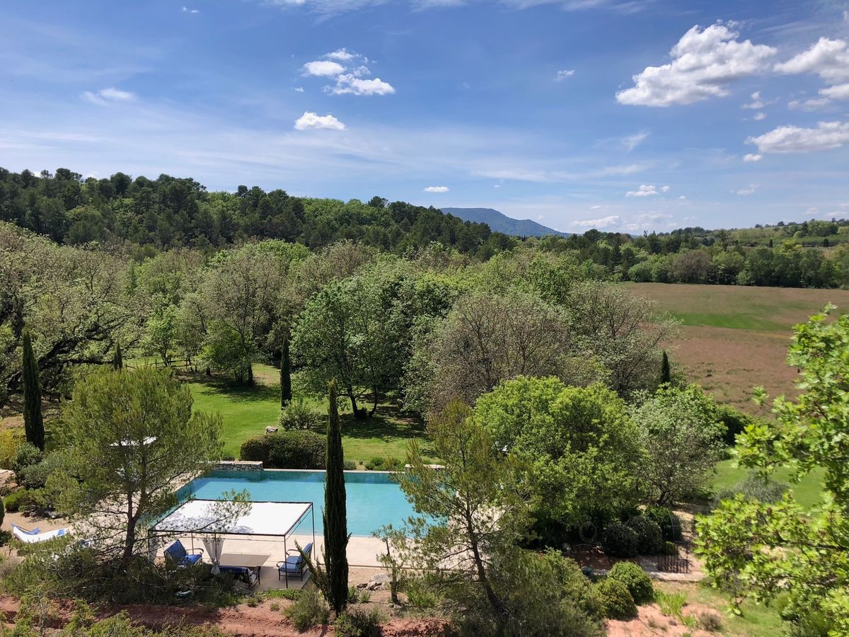 From the high ground of the property: the pool, the trees of the grounds, then fields and wooded hills to the horizon.